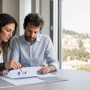 Due colleghi leggono e interpretano un bilancio aziendale durante il corso Finance per Manager di AmniOs